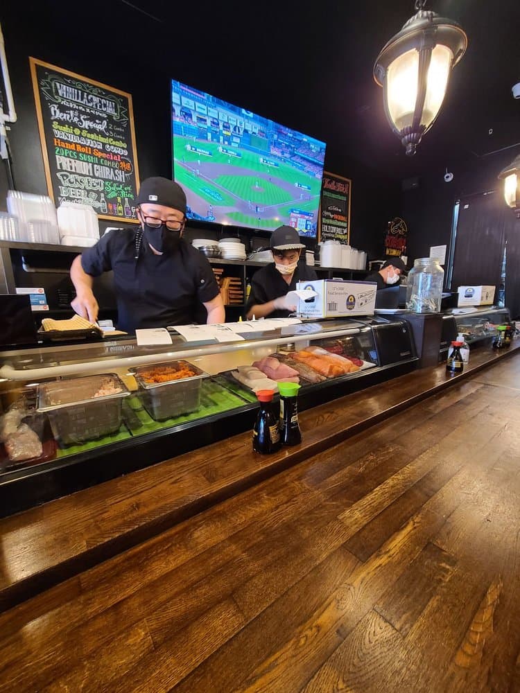 Vanilla Fish sushi chefs behind the counter, prepping fresh cuts of fish